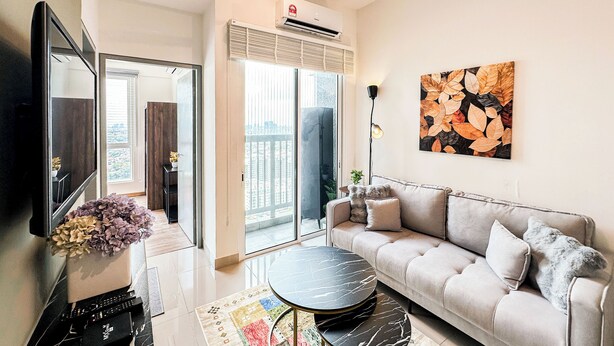 Un salon moderne avec un canapé, une table basse, un téléviseur à écran plat et une grande fenêtre.