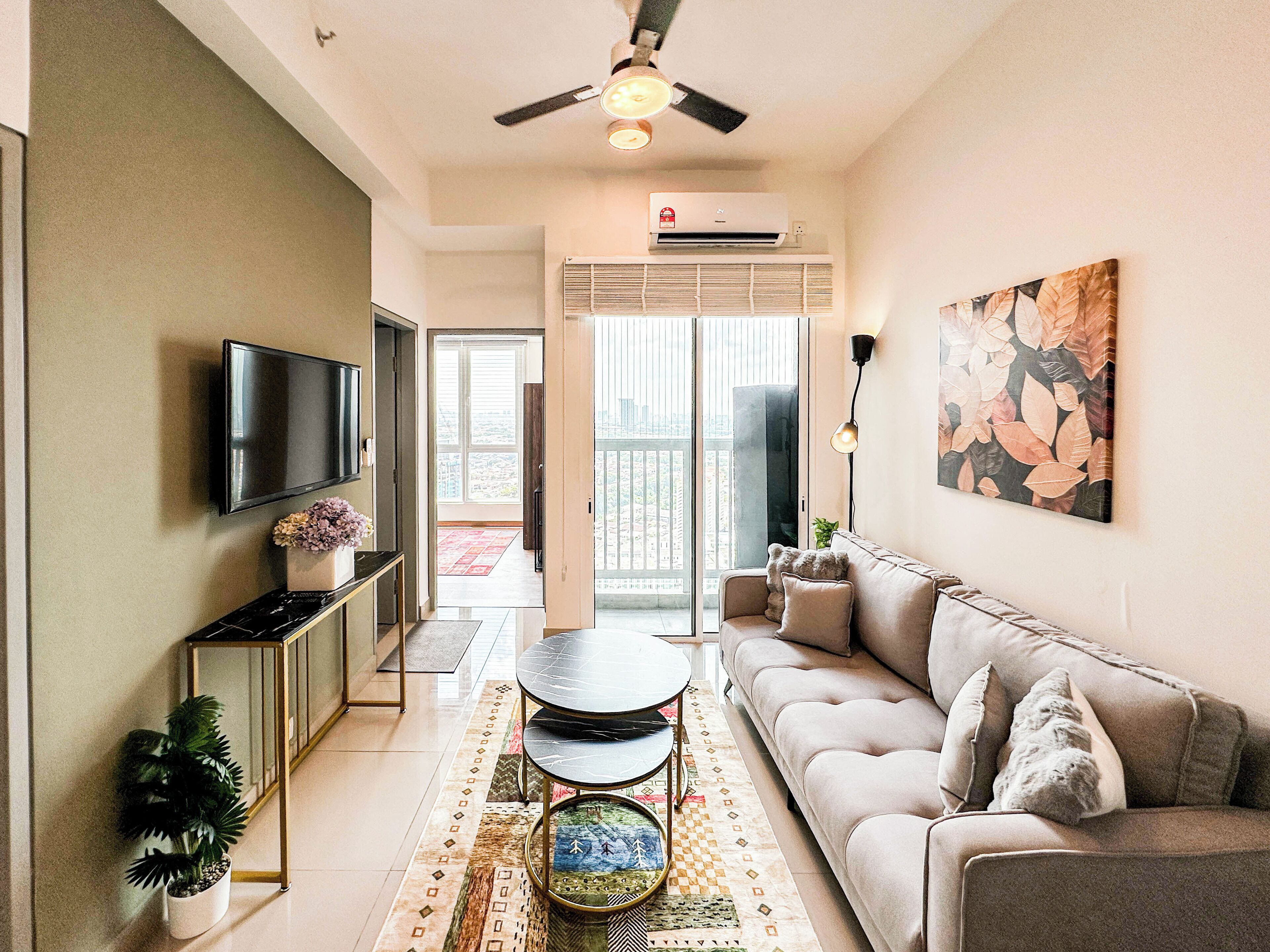 A modern living room with a sofa, TV, and a ceiling fan.