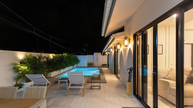 A modern outdoor patio with a pool, seating area, and glass doors leading to a living space. - Newly Renovated Pool Villa with BBQ V296 (Koh Samui)