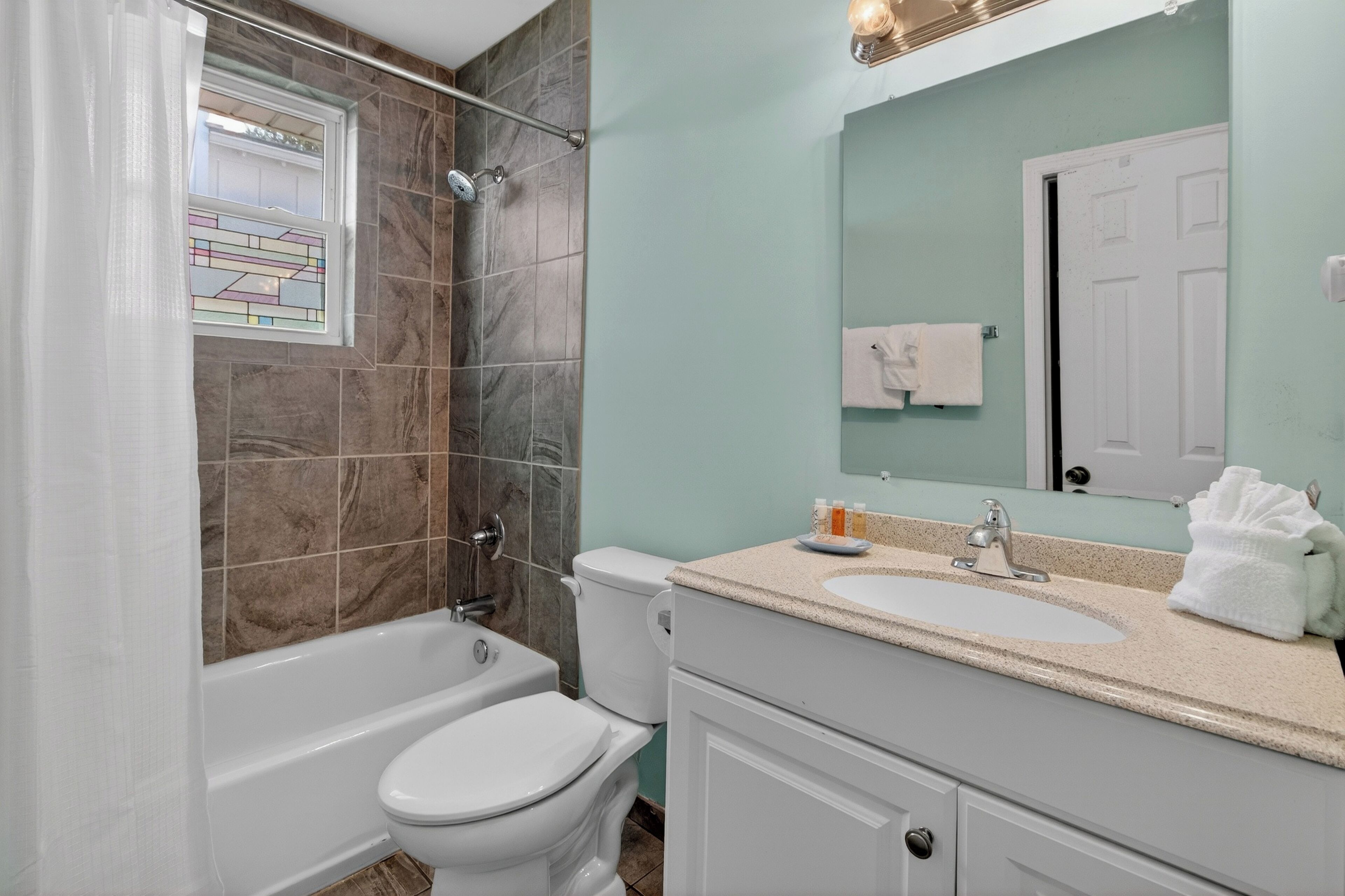 A bathroom with a bathtub, toilet, and sink.