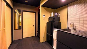 Eine kleine Küche mit Mikrowelle, Spüle und einem Kühlschrank.