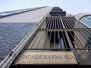 Une façade d’immeuble avec une enseigne indiquant « BAY SIDE KANNAI BLD. »