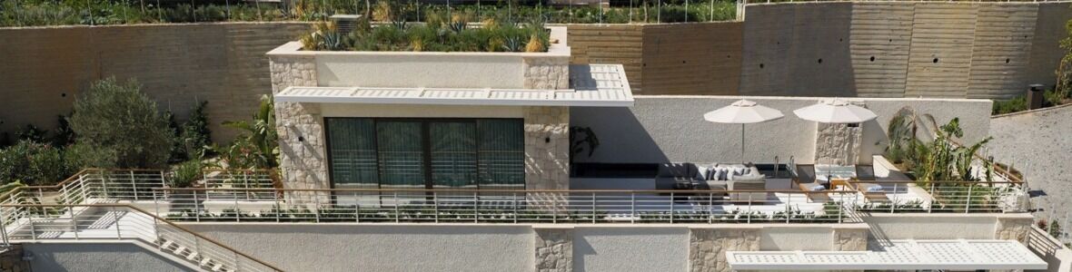 Une terrasse sur le toit avec des sièges extérieurs, une piscine et un mur en pierre.