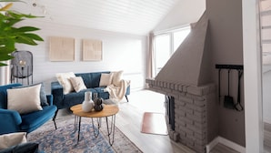 Ein modernes Wohnzimmer mit einem blauen Sofa, einem Couchtisch und einem Kamin.