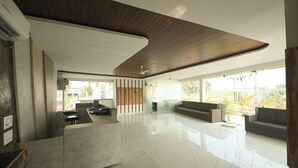 Un interior espacioso y moderno con techo curvo, mostrador de recepción, zona de estar y ventanas amplias con vistas al exterior.