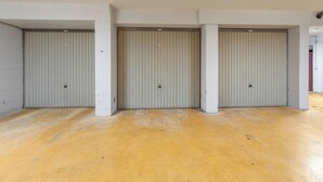 A hallway with three closed metal doors, white walls, and a yellow floor. - 3 bedroom accommodation in Oostduinkerke (Oostduinkerke)
