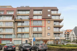 A multi-story residential building with a parking sign, a West Litoral sign, and several cars parked in front. - 3 bedroom accommodation in Oostduinkerke (Oostduinkerke)