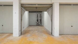 A corridor with two closed doors on either side, a central door with a metal roof, and a concrete floor. - 3 bedroom accommodation in Oostduinkerke (Oostduinkerke)