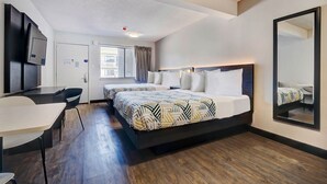 A hotel room with a large bed, a desk, a chair, a television, and a window with curtains. - Studio6 Rock Springs, WY - Flaming Gorge (Rock Springs)