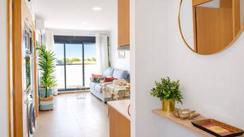 A modern kitchen with a built-in oven, a dining area with a table and chairs, and a large window with a view of the outdoors.