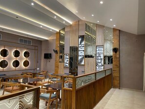 Un café moderne avec des meubles en bois et un comptoir central.