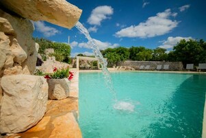 Una piscina al aire libre de temporada, sombrillas