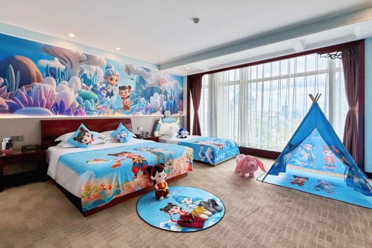 Habitación de hotel con dos camas, un mural grande, una tienda de campaña y una alfombra redonda.