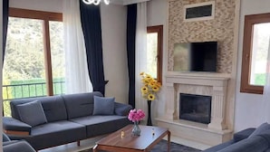 A modern living room with a sectional sofa, a coffee table, and a fireplace.