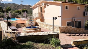 Un edificio con piscina, escalones de piedra y zona de estar al aire libre.