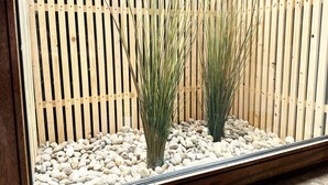 A wooden fence with vertical slats and a gravel base.