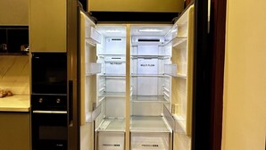 Una cocina moderna con refrigerador, horno y microondas integrados.