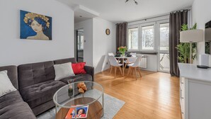 A modern living room with a sofa, coffee table, and artwork on the wall. - Lumina apart with balcony in Warsaw (Warsaw)