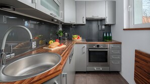 A modern kitchen with stainless steel appliances, a wooden countertop, and a built-in oven. - Lumina apart with balcony in Warsaw (Warsaw)