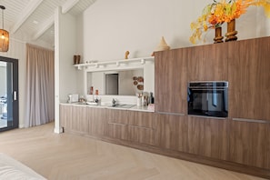 A modern kitchen with wooden cabinets, a built-in oven, and a countertop.