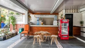 A reception area with a counter, a red telephone, and a small table with stools. - Dhita Kubu Guest House (Kerobokan)