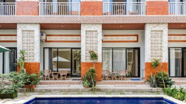 A hotel with a swimming pool, outdoor seating, and a brick facade. - Dhita Kubu Guest House (Kerobokan)