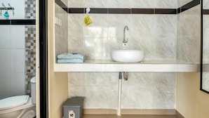 A bathroom with a white sink, a towel, and a toilet. - Dhita Kubu Guest House (Kerobokan)