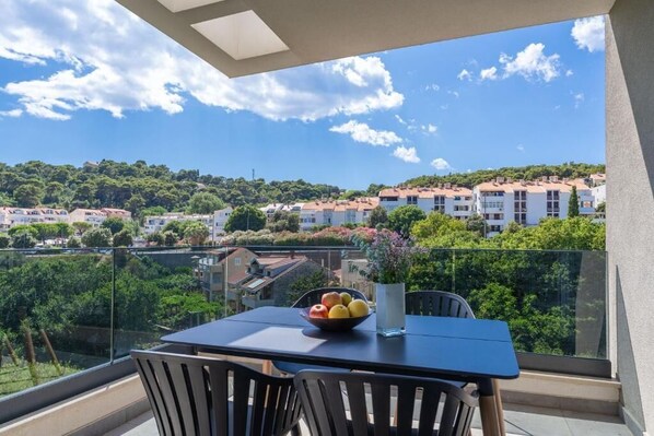 A balcony with a table, chairs, and a bowl of fruit. - THE SIGNATURE SUITE by DuHomes (Dubrovnik)