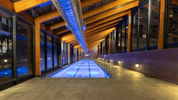A corridor with a pool, wooden beams, and large windows. - Spacious 3BR on Bourke St Grand Balcony & City Views (Melbourne)