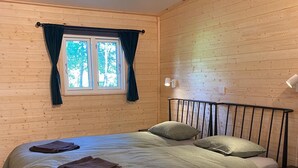 A single bed with a headboard, a window with curtains, and a bedside table. - Villa Ragunda: Peace, space and Swedish adventure in the heart of Jämtland. (Hammarstrand)