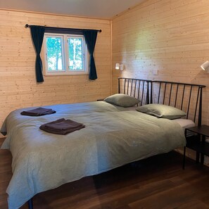 A single bed with a headboard, a window with curtains, and a bedside table. - Villa Ragunda: Peace, space and Swedish adventure in the heart of Jämtland. (Hammarstrand)