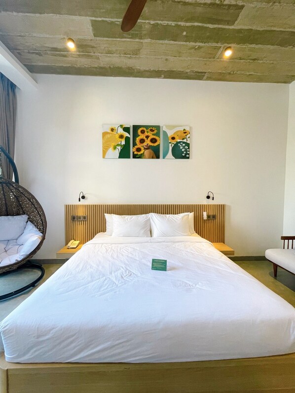 A hotel room with a large bed, a hanging chair, and a wall-mounted artwork. - Tournesol Villa (Xuan Huong - Da Lat)