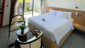 A hotel room with a bed, a ceiling fan, a table with a plant, a chair, and a view of the outdoors through a large window. - Tournesol Villa (Xuan Huong - Da Lat)