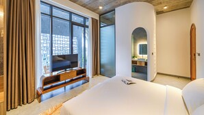 A modern bedroom with a large bed, a TV on a wooden stand, and a view of the outside through large windows. - Tournesol Villa (Xuan Huong - Da Lat)