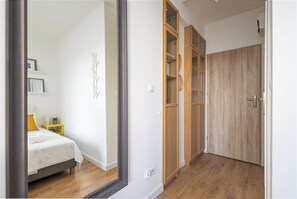 A bedroom with a bed, bedside table, and a mirror. - New World Apartament (Warsaw)