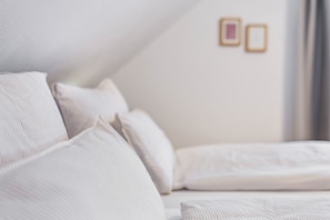 A bed with white bedding and a framed picture on the wall. - Apartment 'Ferienwohung Seidel' with Balcony and Wi-Fi (Angermünde)