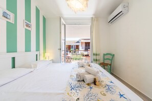 Ein Hotelzimmer mit Bett, einem Sessel, einem Tisch mit Handtüchern und einer Klimaanlage.