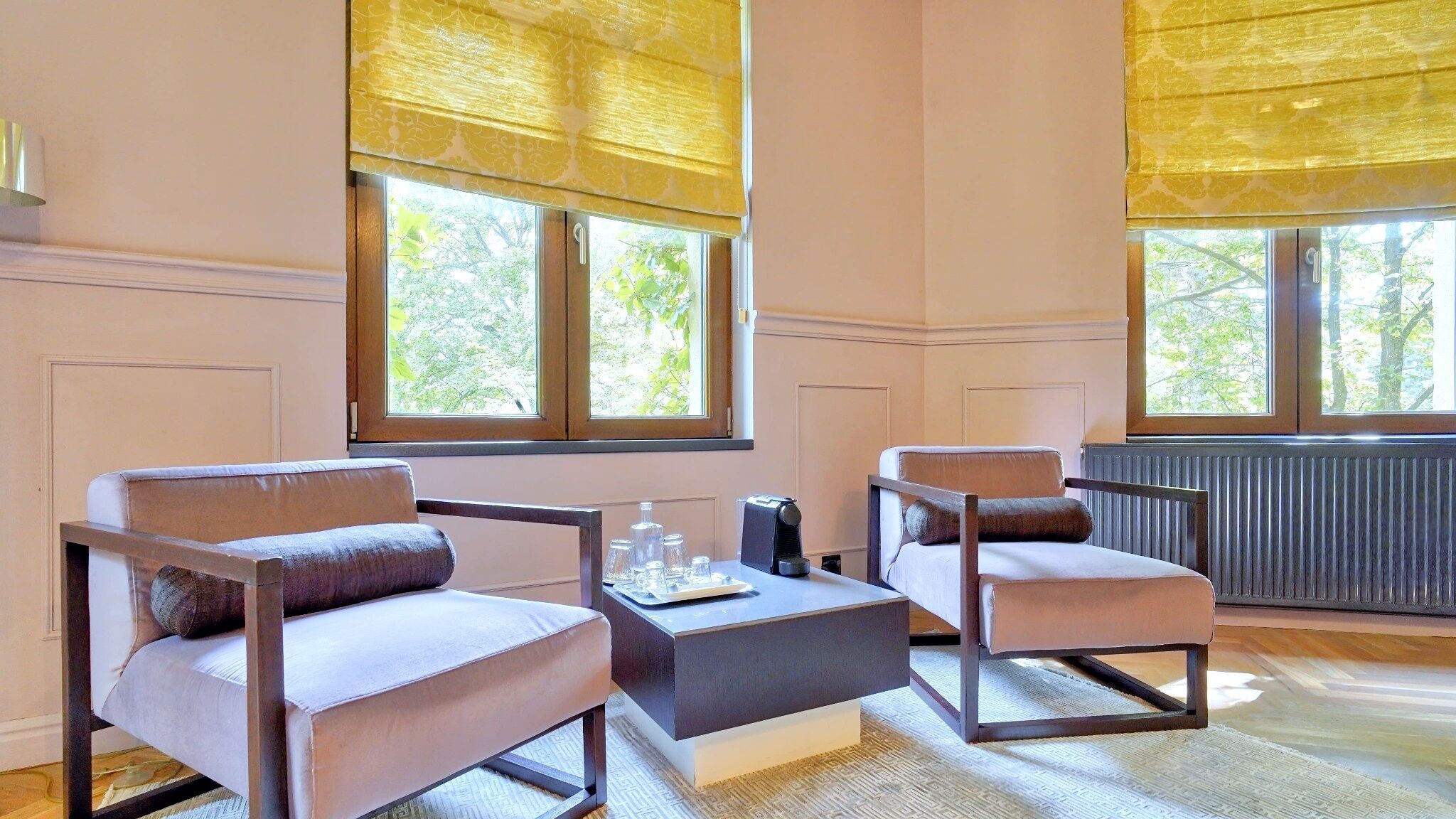 Ein Zimmer mit zwei Sesseln, einem Couchtisch und einer Heizung.