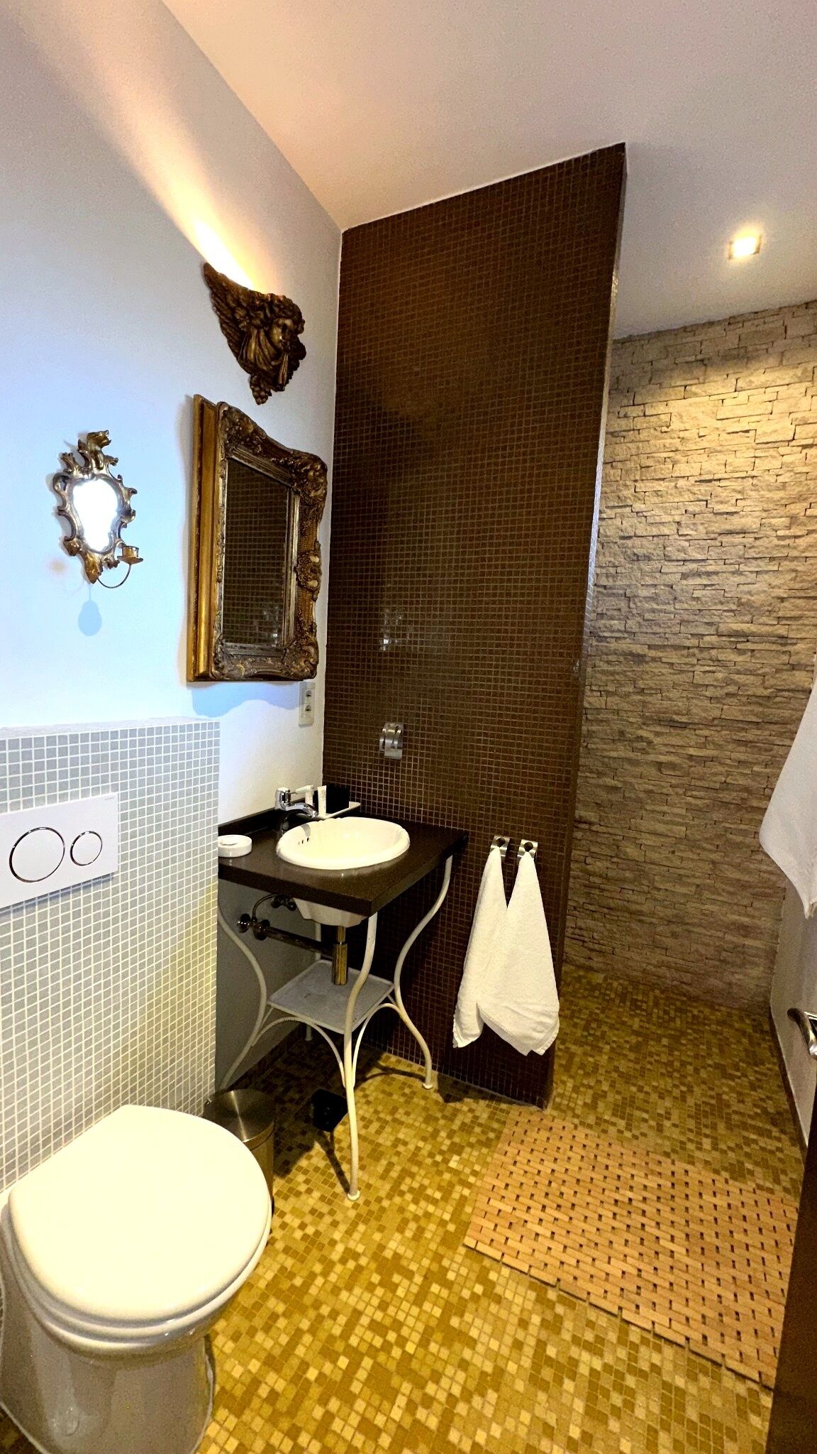 Une salle de bain avec un lavabo, un miroir et des toilettes.