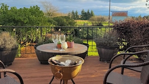 A deck with outdoor furniture, a grill, and a view of the countryside. - Rustic villa vacation rental near Mount Rainier with farm charm, (Enumclaw)