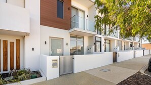 A modern apartment building with a clean, minimalist design, featuring large windows and a gated entrance. - Casa Tranquilla - Short Walk to North Coogee Beach (North Coogee)