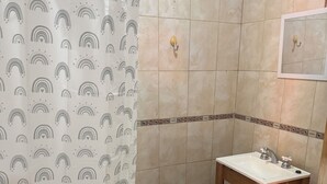 Un baño con cortina de ducha, lavabo e inodoro.