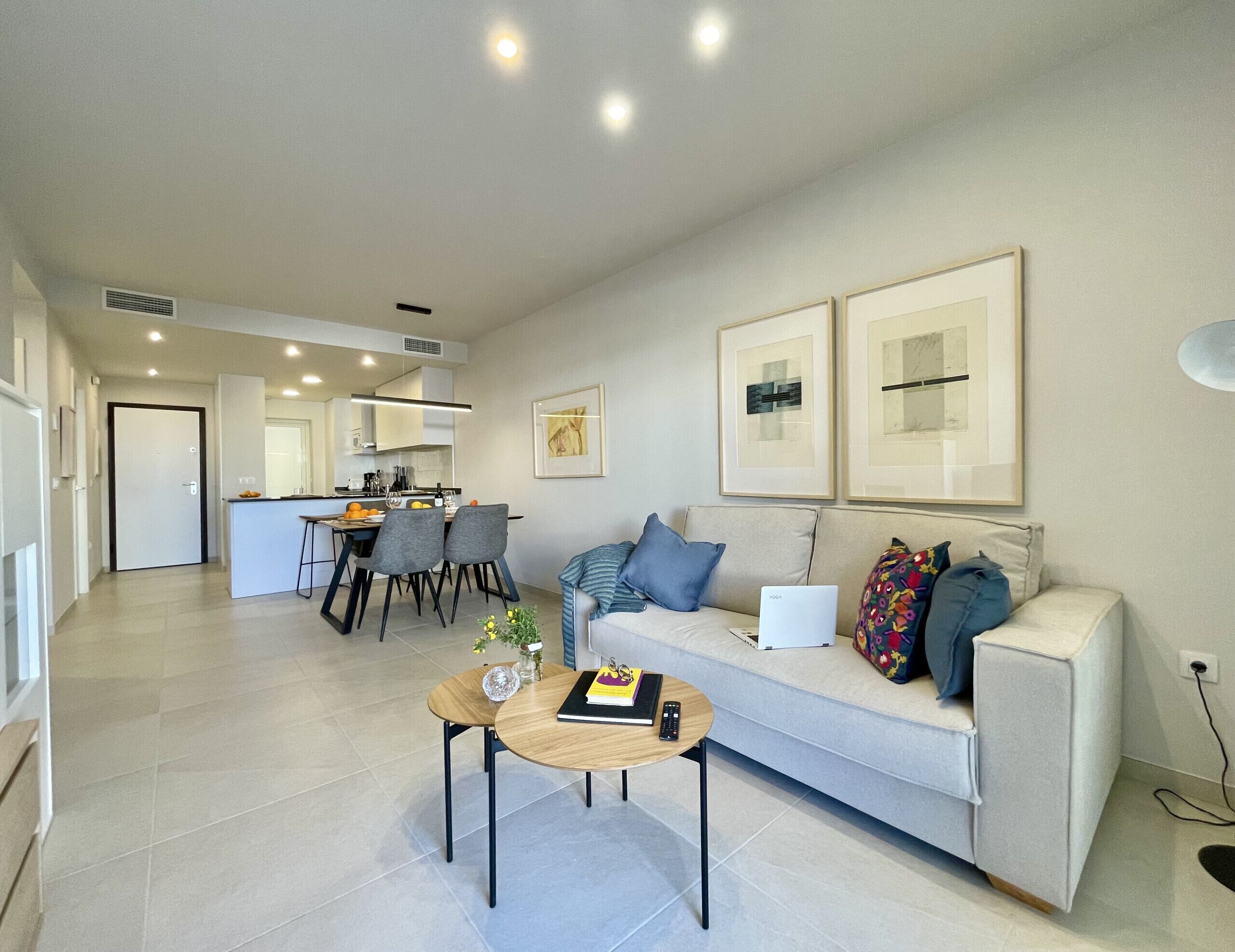 Un salon moderne comprenant un canapé, une table basse et un coin repas avec des chaises et une table.