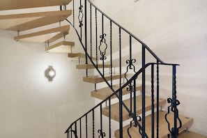 Una escalera con escalones de madera y barandillas de metal negro.