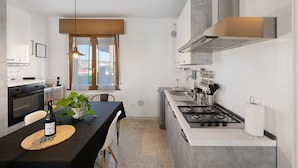 A modern kitchen with a gas stove, a sink, and a window with blinds. - Apartment 'Ca' Mirabello' with Wi-Fi and Air Conditioning (Bardolino)