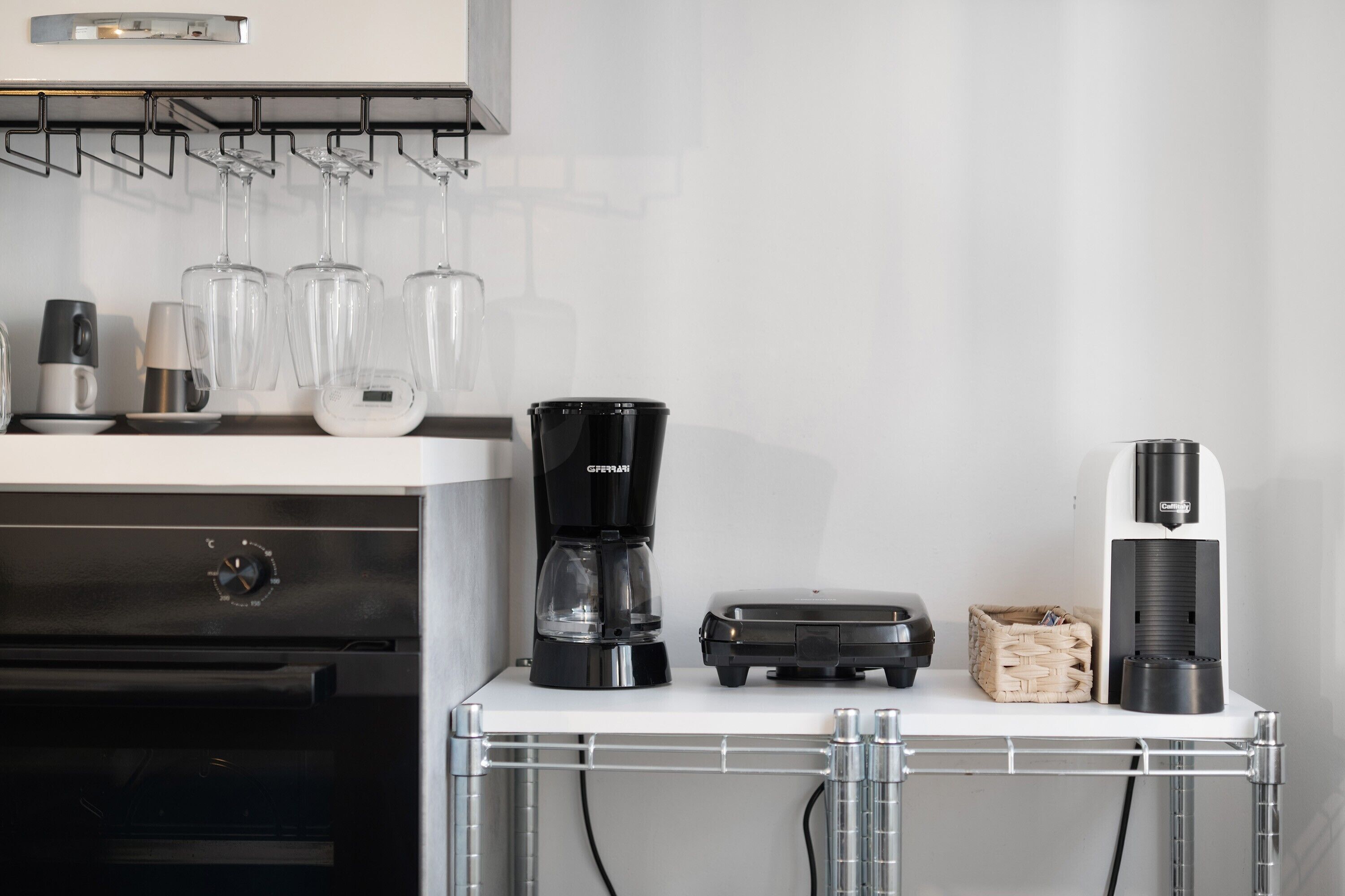 A kitchen with a coffee maker, a toaster, and a glass rack.