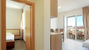 Een hotelkamer met een bed, een bureau, een stoel en uitzicht op buiten.
