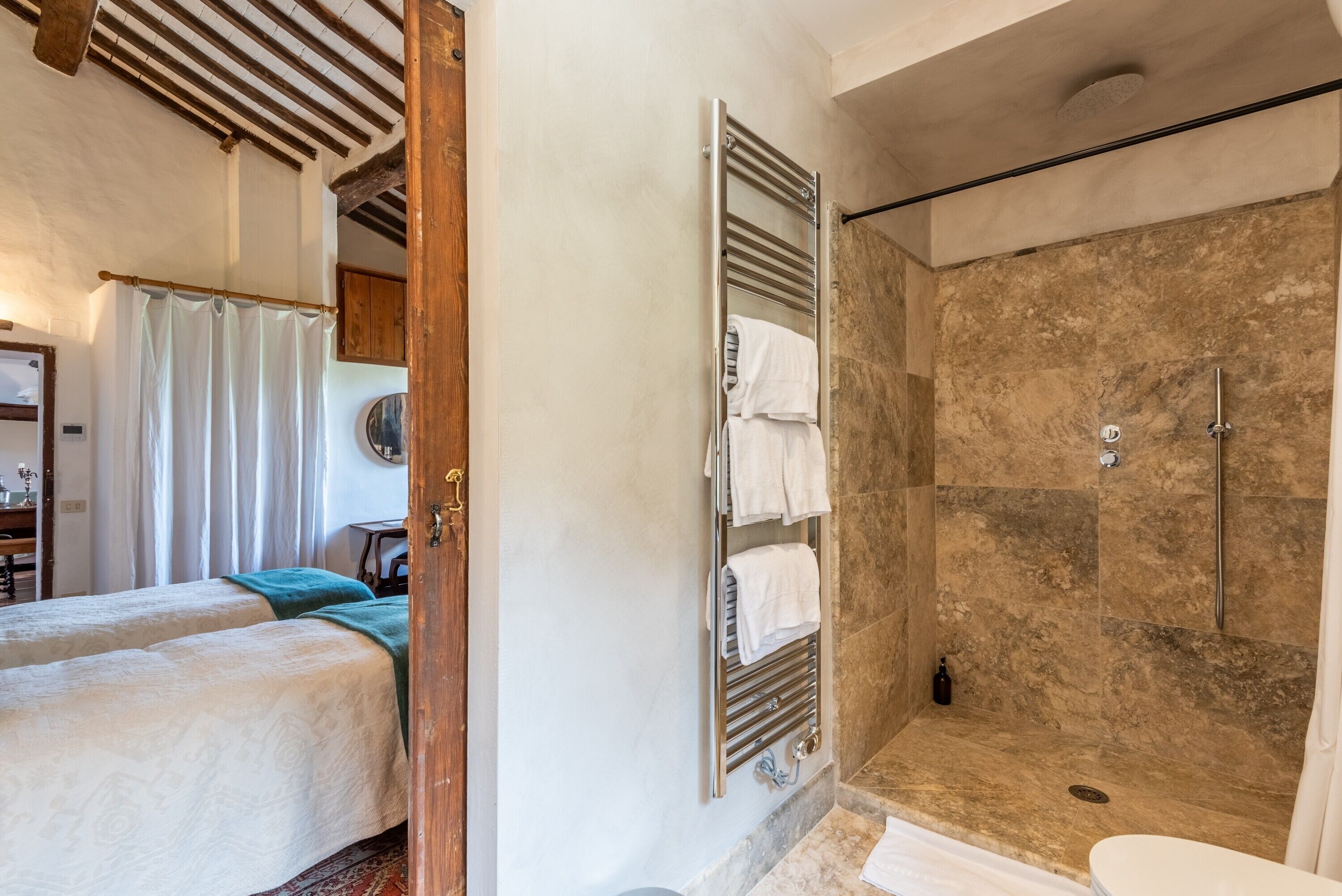 A bathroom with a shower, a toilet, and a towel rack.