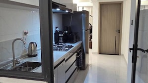 A modern kitchen with a stainless steel sink, a coffee maker, and a stove. - Brand New Westlands 2BR 2Ba Walk to Sarit GTC (Nairobi)
