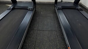 Two treadmills with digital displays, a window with a view of a construction crane and buildings, and a tiled floor. - Brand New Westlands 2BR 2Ba Walk to Sarit GTC (Nairobi)